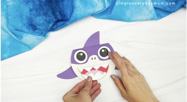 hand gluing mouth to shark card craft