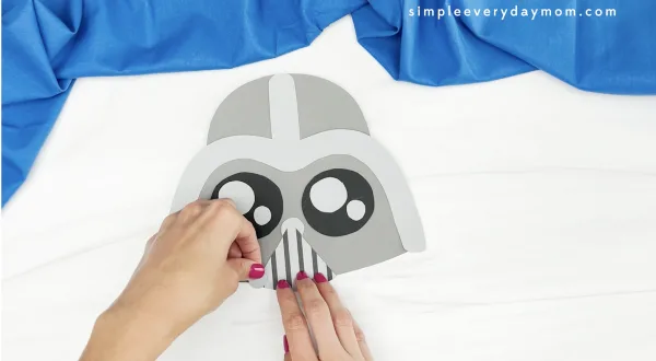 hand gluing circle to Darth Vader paper bag puppet craft