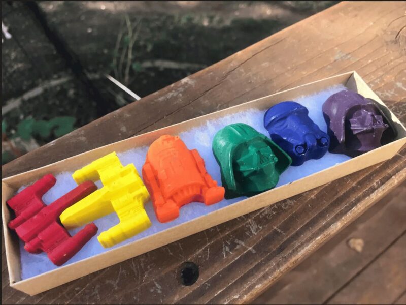 Overhead view of a box of multi colored star wars crayons.