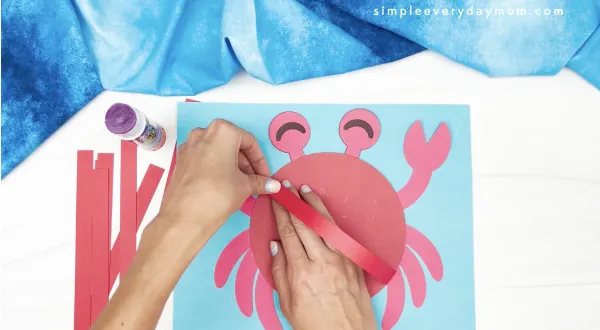 hand gluing 3d strip to crab craft