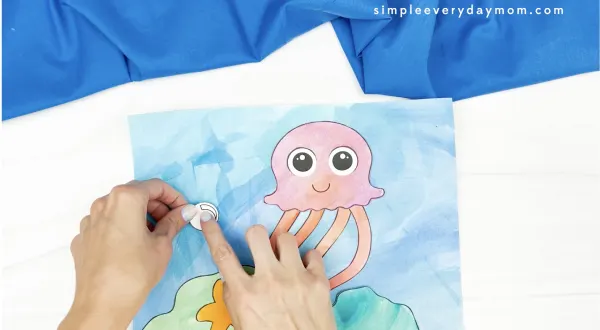hand gluing bubble to jellyfish painting