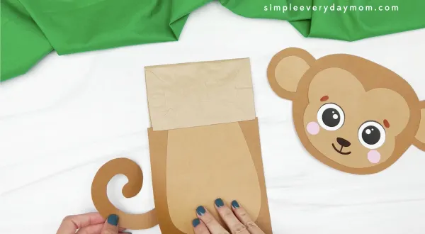 hand gluing tail to monkey puppet craft