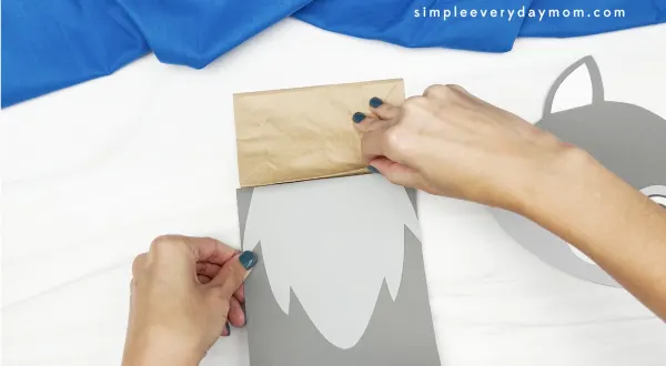 hand gluing body to wolf puppet craft