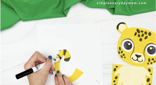 hand drawing spots onto cheetah puppet craft