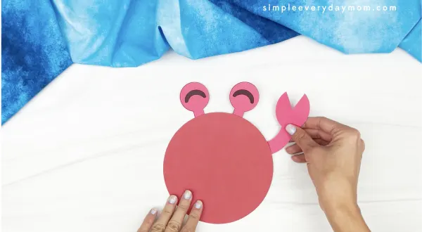 hand gluing claw to 3d crab craft