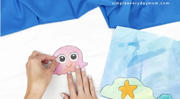hand gluing eye to jellyfish craft