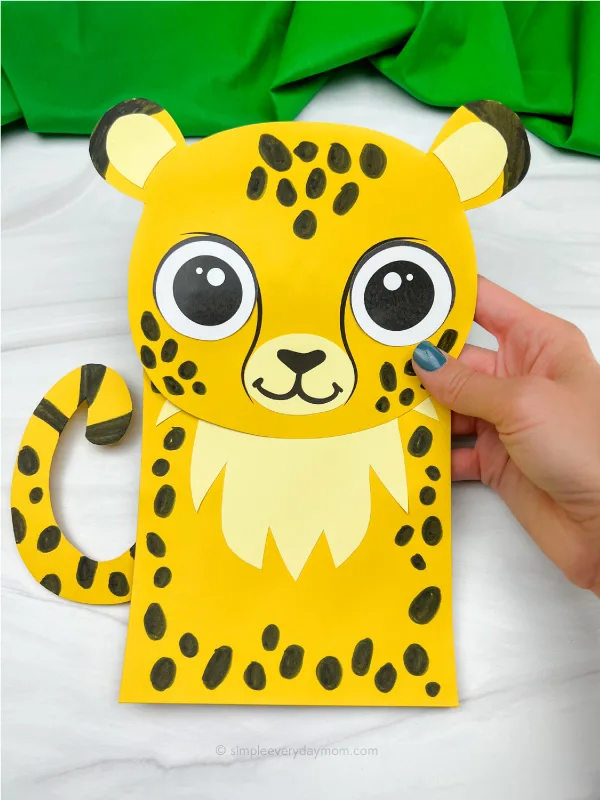 hand holding cheetah paper bag puppet