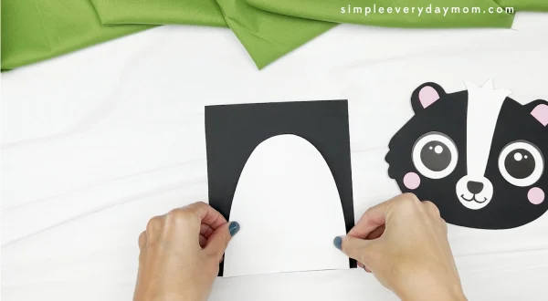 hand gluing belly to skunk paper bag craft