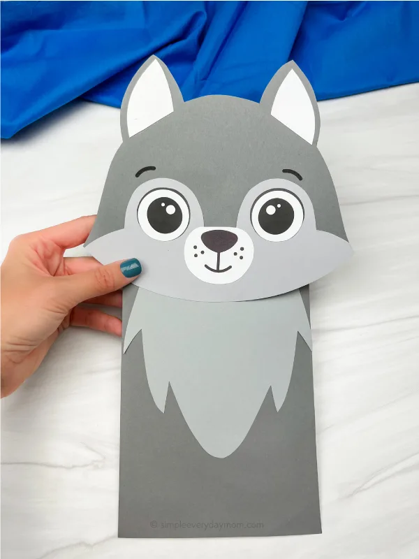 hand holding wolf paper bag puppet