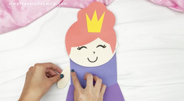 hand gluing arm to princess puppet craft