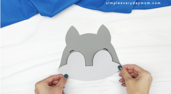 hand gluing lower face to wolf puppet craft