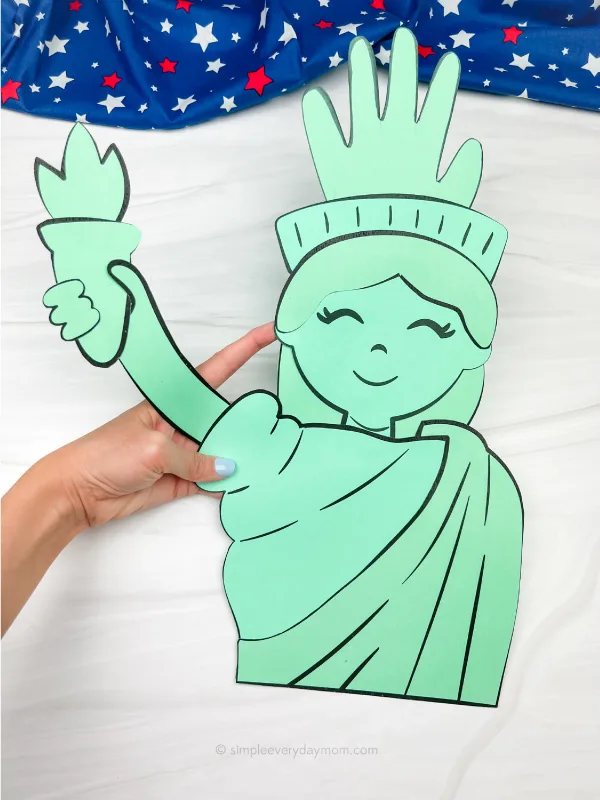 hand holding Statue of Liberty craft