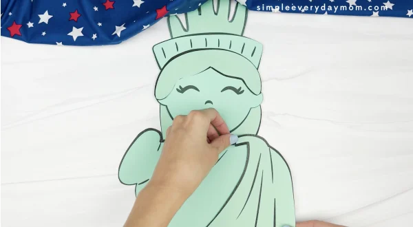 hand gluing robe to handprint Statue of Liberty craft