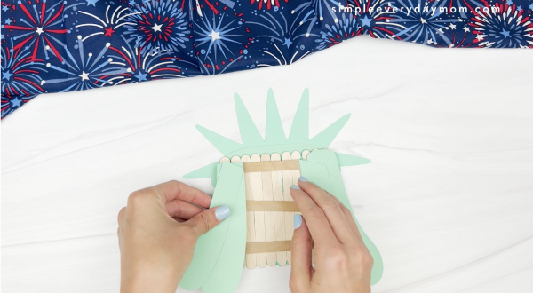hand gluing hair to popsicle stick Statue of LIberty craft