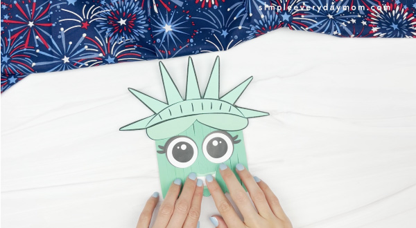 hand gluing teeth to popsicle stick Statue of LIberty craft