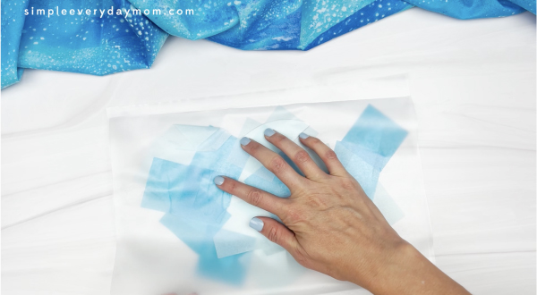 hand placing contact paper onto tissue paper