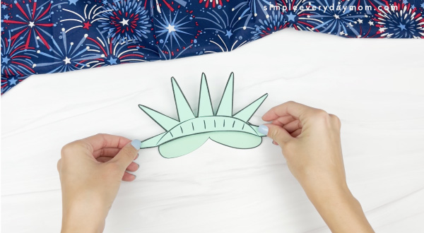 hand gluing crown to popsicle stick Statue of LIberty craft