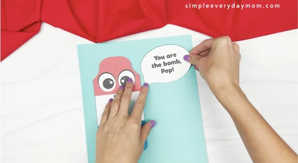 hand gluing speech bubble to Father's Day popsicle craft