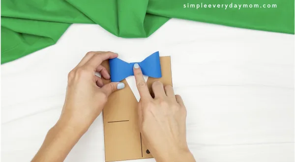 hand gluing bowtie to Father's Day card craft