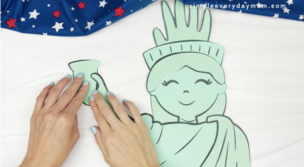 hand gluing torch to handprint Statue of Liberty craft