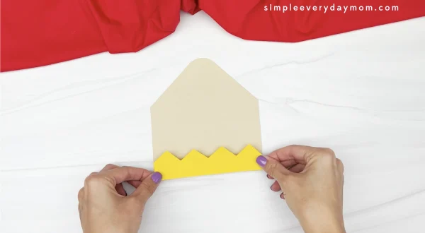 hand gluing zig zag to pencil puppet craft