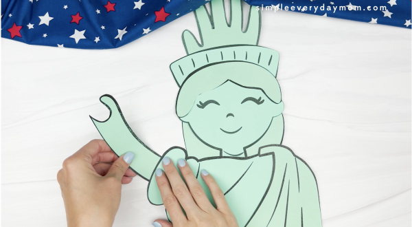 hand gluing arm to handprint Statue of Liberty craft