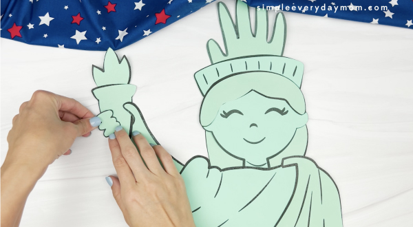 hand gluing fingers to handprint Statue of Liberty craft