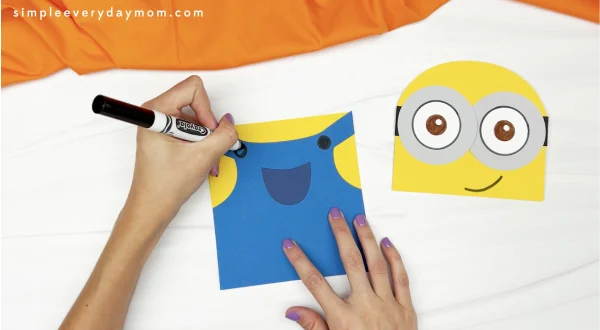 hand drawing buttons onto minion puppet