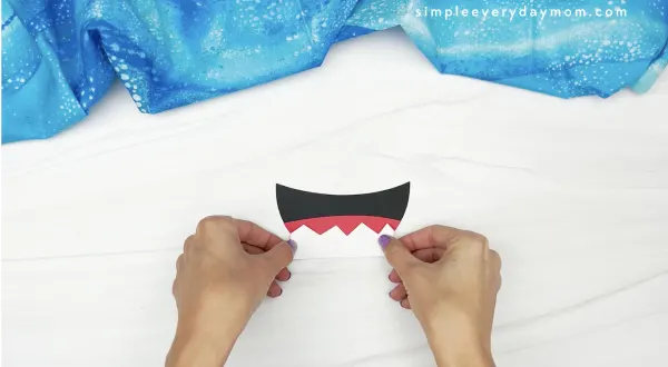 hand gluing teeth to paper plate shark