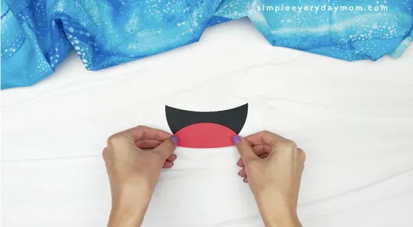 hand gluing tongue to paper plate shark