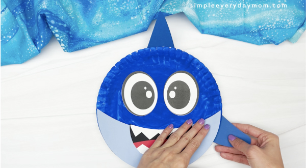 hand gluing side fin to paper plate shark