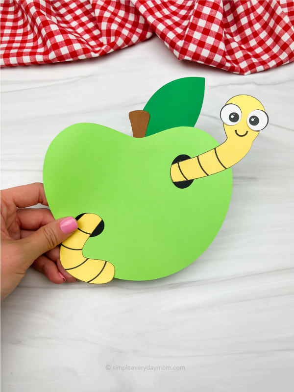hand holding worm in apple craft