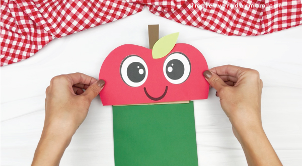 hand gluing upper apple to paper bag apple craft