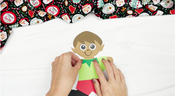 hand gluing shirt collar to elf gingerbread man in disguise craft
