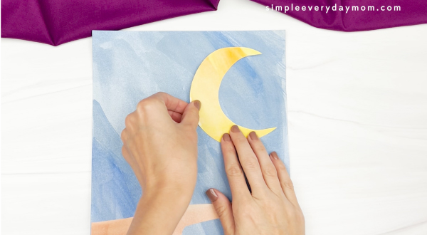 hand gluing moon to watercolor background