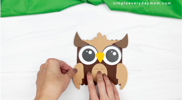 hands gluing wing to owl popsicle stick craft