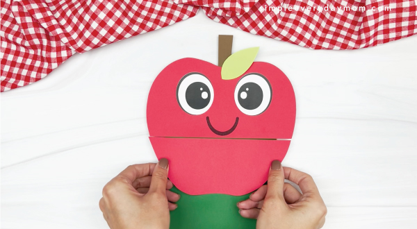 hand gluing lower apple to paper bag apple craft