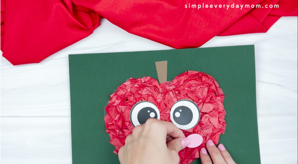hand gluing cheek to tissue paper apple craft