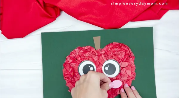 hand gluing cheek to tissue paper apple craft