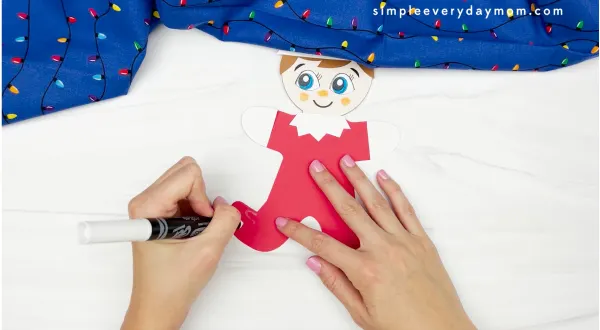 hand drawing gingerbread icing onto elf on the shelf gingerbread man disguise craft
