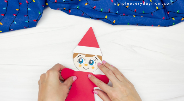 hand gluing body to elf on the shelf gingerbread man disguise craft