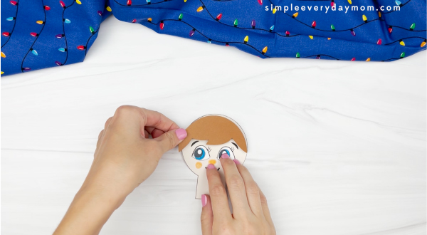 hand gluing hair to elf on the shelf gingerbread man disguise craft