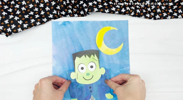 hand gluing Frankenstein to watercolor background paper