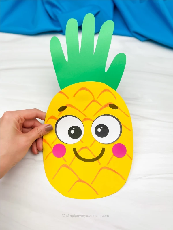 hand holding handprint pineapple craft
