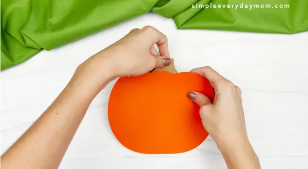 hand gluing stem to pumpkin emotion craft