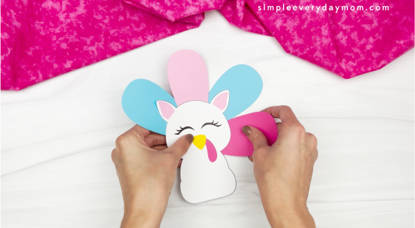 hand gluing feather to unicorn turkey in disguise craft
