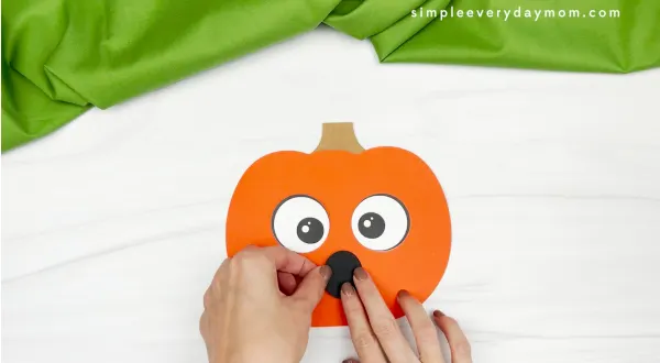 hand gluing mouth to pumpkin emotion craft