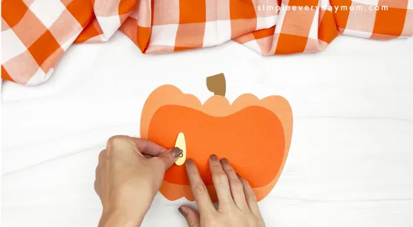 hand gluing seeds onto pumpkin name craft