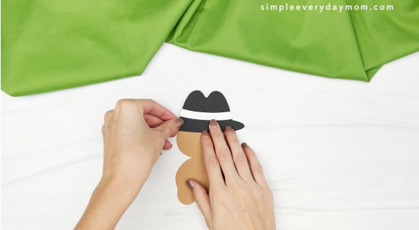 hand gluing hat to turkey body of spy turkey craft