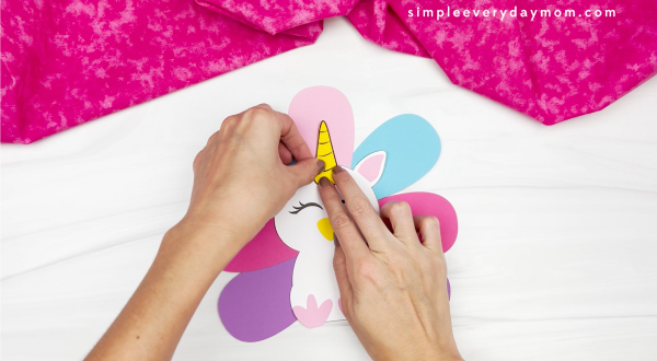 hand gluing horn to unicorn turkey in disguise craft